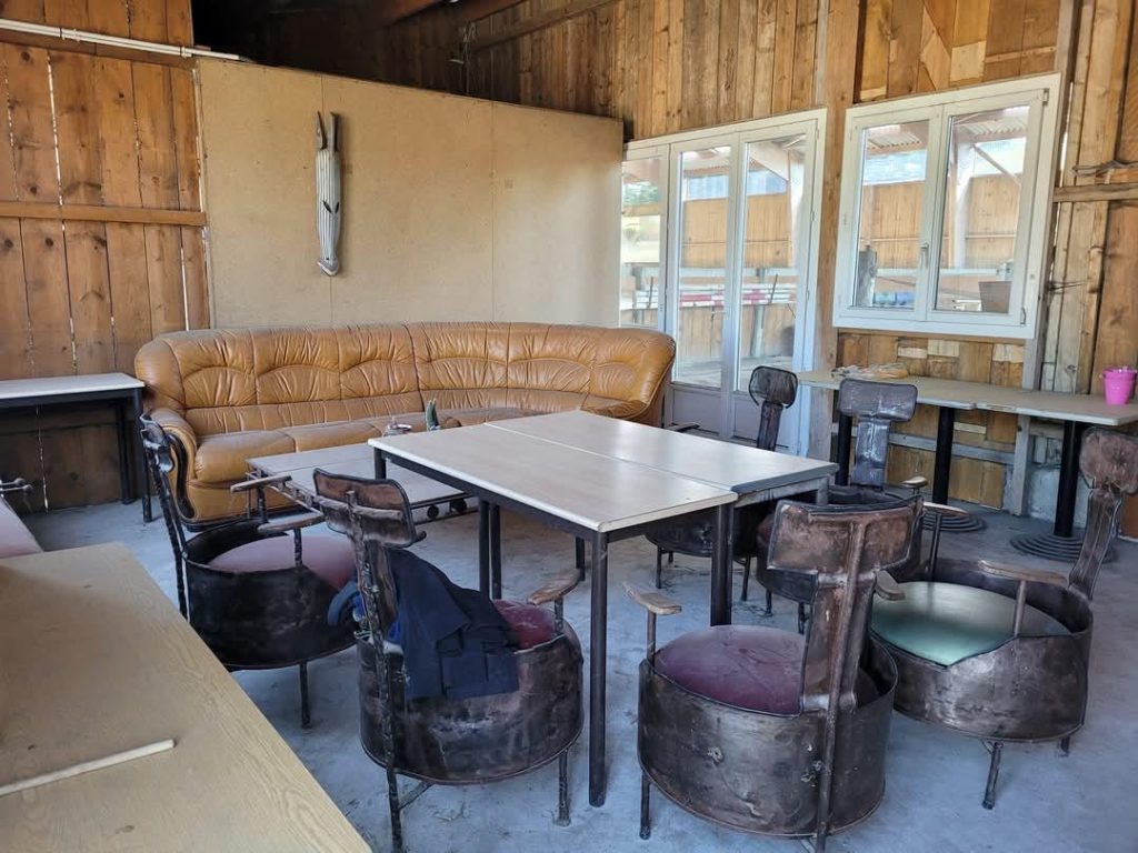 Club house chaleureux dans les installations équestres du Val-d’Oise avec canapés et mobilier rustique