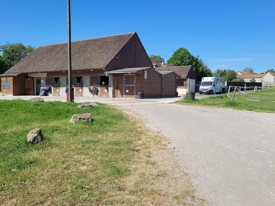 Vue extérieure des boxes en bois et des installations modernes de notre pension pour chevaux.