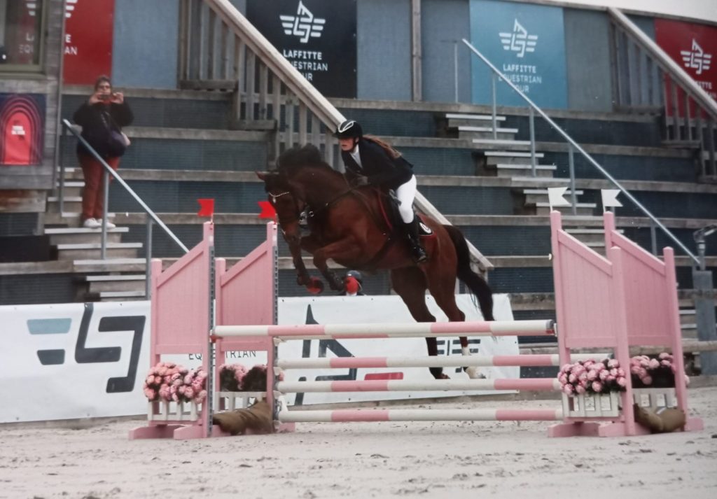 Naomie Monitrice d'Équitation Écuries des Mottes, en plein saut d'obstacle lors d’un concours équestre